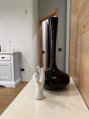 a black vase sitting on a counter next to a statue at Villa Tattoo in Donoratico