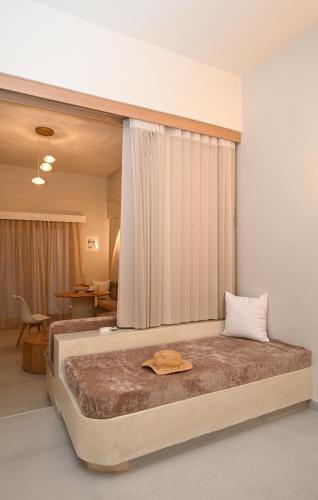 a bedroom with a large bed with a hat on it at Skalia Mountain & Sea Suites in Skaliá
