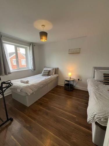 a bedroom with two beds and a window at Trowbridge House Long Stays Free Parking and Wifi in Swindon