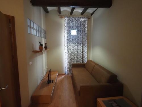 a living room with a couch and a window at Apartaments El Jaç in Montblanc