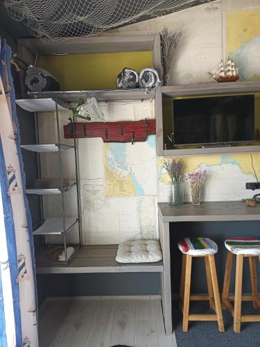 a bunk bed in a room with a desk and two stools at Guest House Serena in Chornomorsk
