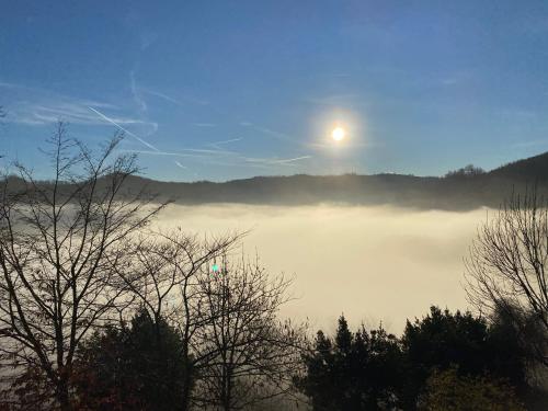 a view of a foggy lake with the moon in the sky at I Pesci De Boschi in Borgo Priolo