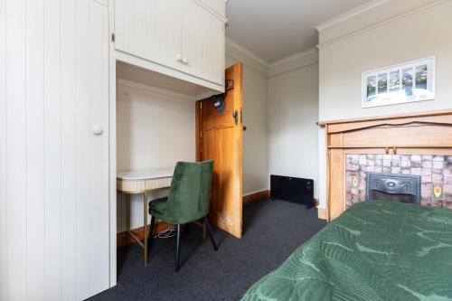 a bedroom with a bed and a desk and a fireplace at 2 Storey Villa, Games room, Ski storage in Methven