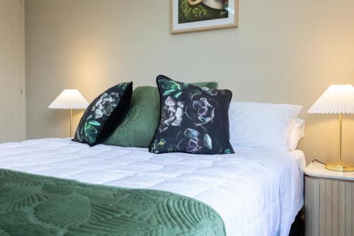a bedroom with a bed with pillows and two lamps at 2 Storey Villa, Games room, Ski storage in Methven