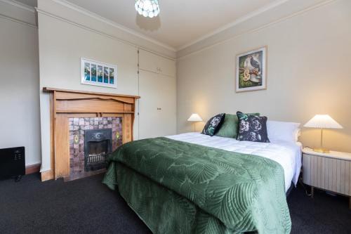 a bedroom with a large bed and a fireplace at 2 Storey Villa, Games room, Ski storage in Methven