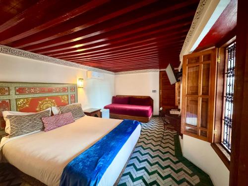 a bedroom with a large bed and a red ceiling at Palais Nazha Fes - Luxury Lodging in Fès