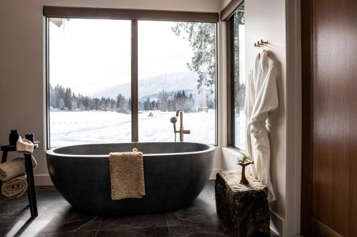 レベルストークにあるMountain Lake Luxury Ski Chaletの窓のある浴室に大きな浴槽がある