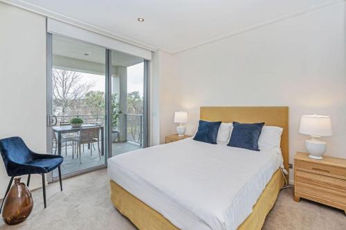 a bedroom with a large bed and a balcony at Glebe Park Cityside with Style in Canberra