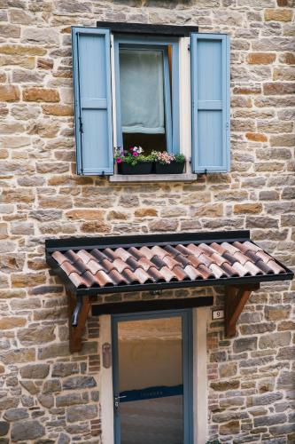 a window with blue shutters and flowers on a building at Locanda Vecchio Caseificio in Toano