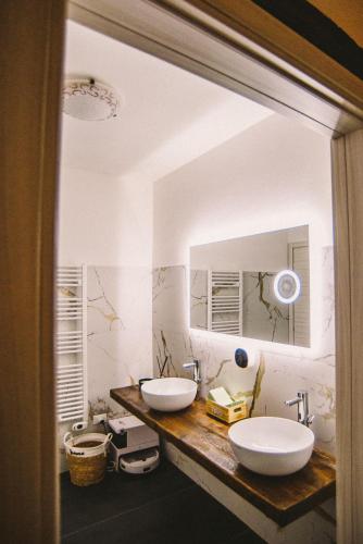 a bathroom with two sinks and a mirror at Locanda Vecchio Caseificio in Toano