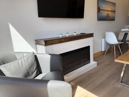 a living room with a fireplace with a flat screen tv at Royalty Maples Motel & Cottages in Charlottetown