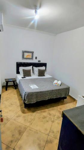 a bedroom with a bed in the corner of a room at Hotel Pousada Iracemar - Piscina Aquecida in Guarujá