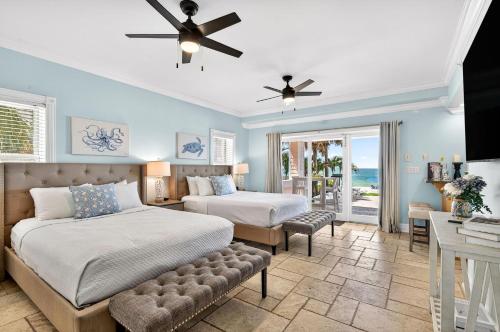 2 letti in una camera da letto con pareti blu e ventilatore a soffitto di Ocean Sands a Clearwater Beach