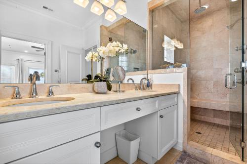 un bagno con due lavandini e una doccia di Ocean Sands a Clearwater Beach