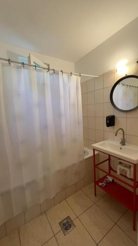 a bathroom with a shower curtain and a sink at Heera Apartman in Hajdúszoboszló