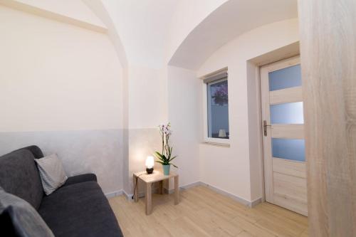 a living room with a couch and a door at Storczyk in Duszniki Zdrój