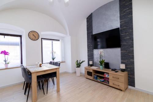 a living room with a dining room table and a tv at Storczyk in Duszniki Zdrój