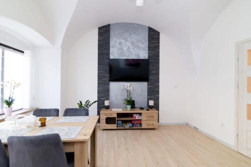 a living room with a table and a tv at Storczyk in Duszniki Zdrój