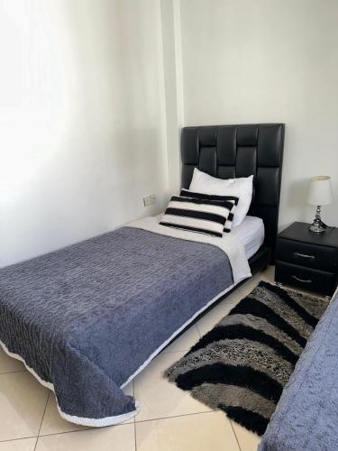 a bedroom with a large bed with a black headboard at Appartement familial a les portes de gueliz in Marrakech