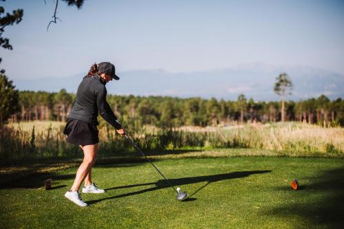 a woman is playing golf on a golf course at Flying Horse Resort & Club in Colorado Springs