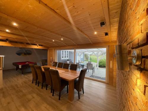 ein Esszimmer mit einem Holztisch und Stühlen in der Unterkunft Ferienhaus Swinemünde mit Sauna und Whirlpool exkl buchbar in Tönning