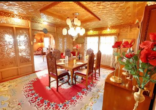 a dining room with a table with chairs and roses at The Royal hareem group of houseboats in Srinagar