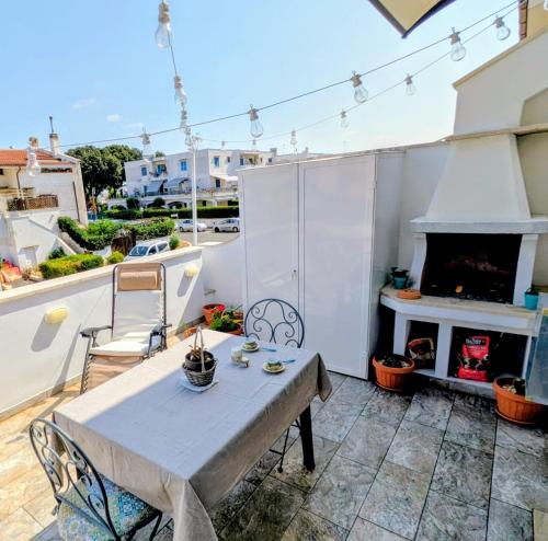 una mesa y sillas en un balcón con chimenea en Edo apartment, en Marina di Cerveteri