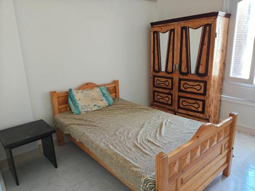 a bedroom with a wooden bed and a wooden dresser at Cozy apartment in Marsa Matruh