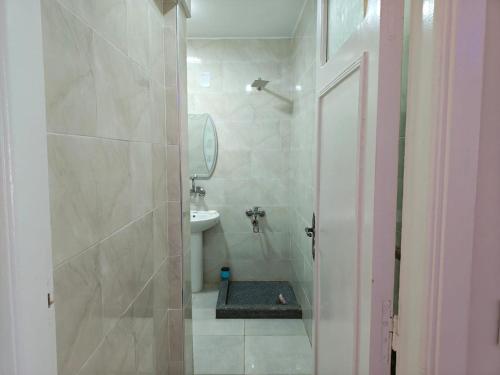 a bathroom with a shower with a sink and a toilet at Cozy apartment in Marsa Matruh