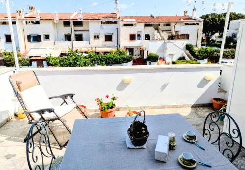 Una mesa y sillas en un balcón con vista a un edificio. en Edo apartment, en Marina di Cerveteri