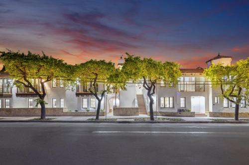 a large white building with trees in front of it at Casa Riviera - Boutique Apartments in Downtown Santa Barbara in Santa Barbara