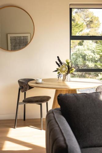 a living room with a table and a mirror at Valley's Embrace Apartment 7 in Hermanus