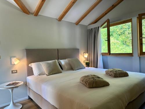 a bedroom with a large bed with two pillows on it at Alchimia WellResort in Comano Terme