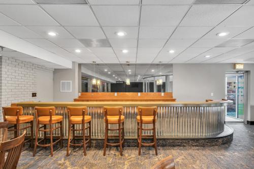 a bar with brown stools in a waiting room at Hotel O Suites & Conference Centre Urbana-Champaign University in Urbana