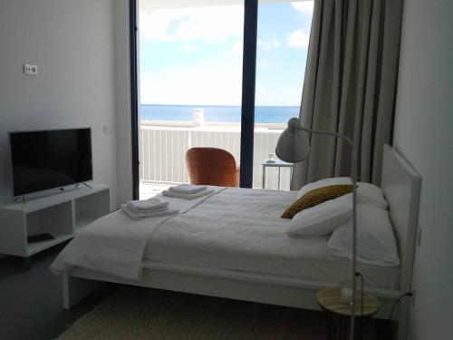 a bedroom with a bed and a view of the ocean at Sargo, vistas espectaculares entre mar y volcán in Punta de Mujeres