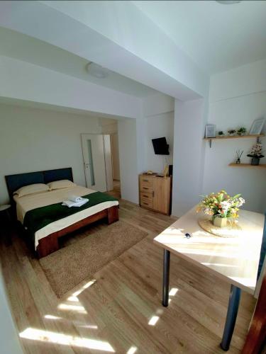 a bedroom with a bed and a table in it at Palas Center Loft in Iaşi