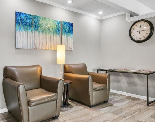 a waiting room with two chairs and a clock at Hotel O Suites & Conference Centre Urbana-Champaign University in Urbana