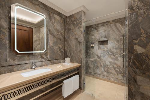 a bathroom with a sink and a shower at Hotel Hillock Ahmedabad in Ahmedabad
