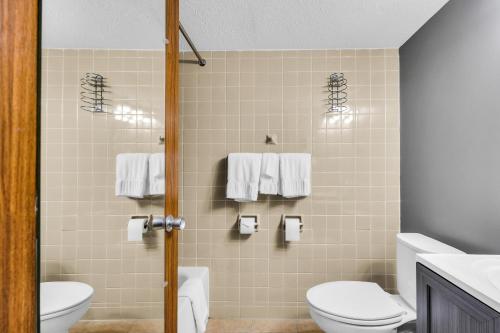 a bathroom with a toilet and a sink at Hotel O Suites & Conference Centre Urbana-Champaign University in Urbana