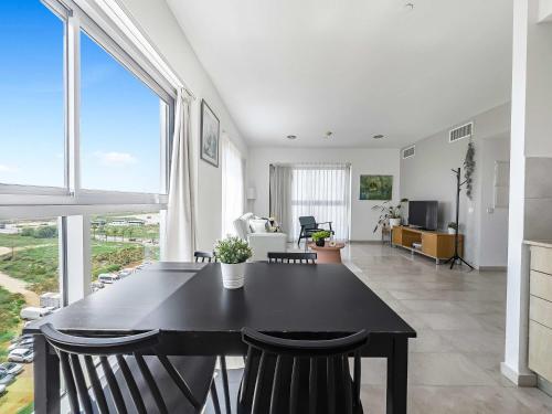 a living room with a black table and chairs at Shoreline Urban Suite in Herzliya B