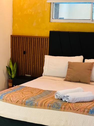 a bed with two towels sitting on top of it at Coffee House Minca in Minca