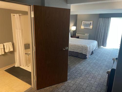 a hotel room with a bed and a window at Hotel O Suites & Conference Centre Urbana-Champaign University in Urbana