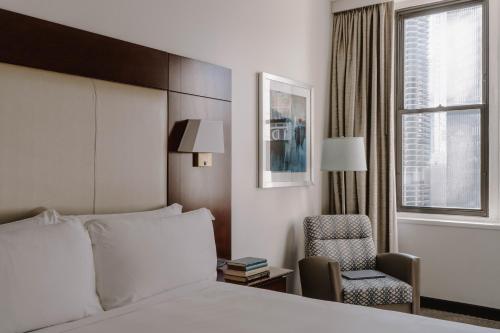 a hotel room with a bed and a chair and a window at River Hotel in Chicago