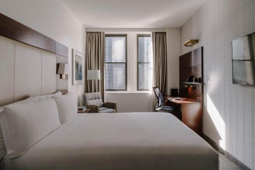 a hotel room with a large white bed and a desk at River Hotel in Chicago