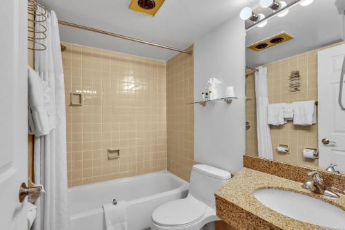 a bathroom with a tub and a toilet and a sink at Hotel O Suites & Conference Centre Urbana-Champaign University in Urbana
