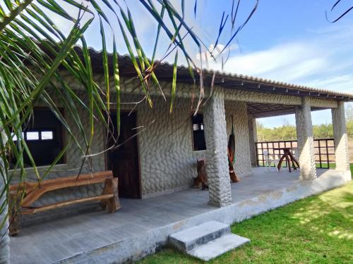 Ein Resort mit einer Terrasse mit einem Tisch und Bänken in der Unterkunft casa do conde in Luis Correia