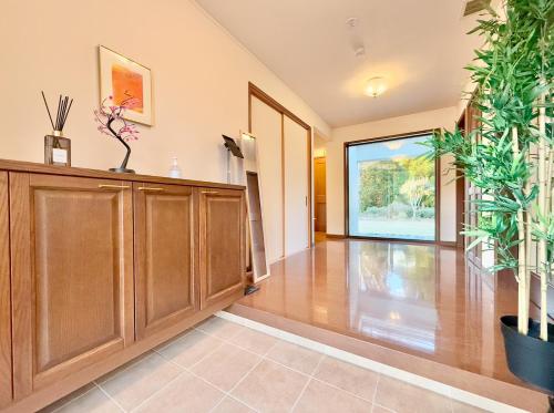 a living room with wooden cabinets and plants at FUWARI-kumamoto- in Aso