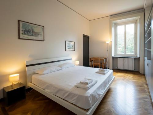 a bedroom with a bed with white sheets and a window at LuxRent Penthouse Crimea in Turin