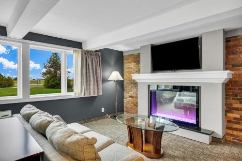 a living room with a couch and a tv at Hotel O Suites & Conference Centre Urbana-Champaign University in Urbana