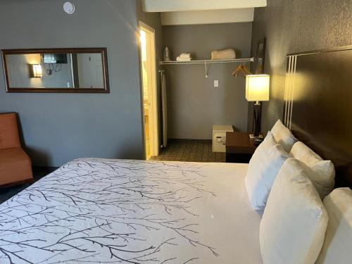 a hotel room with a large bed and a mirror at Hotel O Suites & Conference Centre Urbana-Champaign University in Urbana